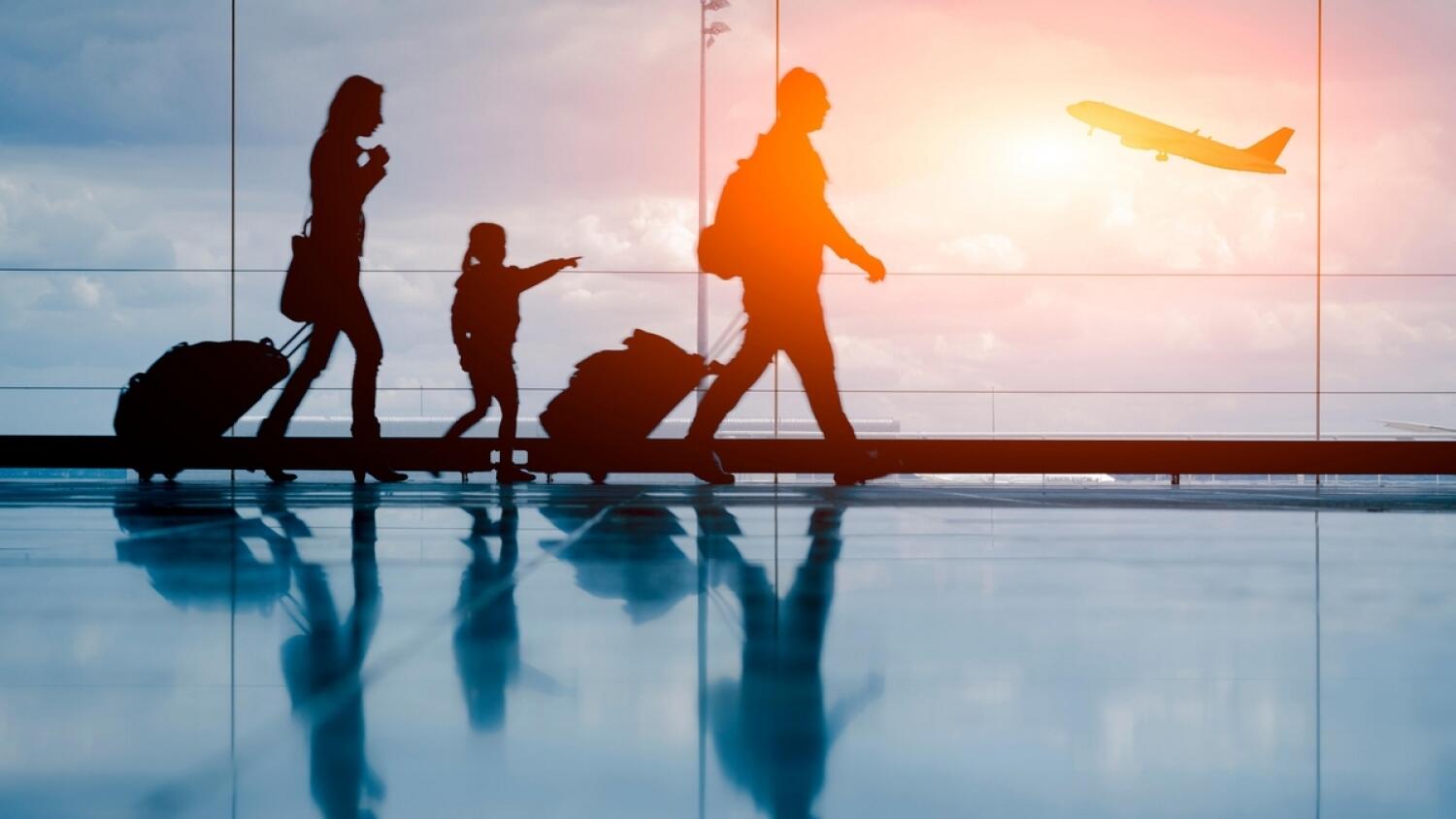 H4BF96 Silhouette of young family and airplane at airport